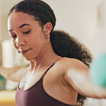 A woman doing one of the best YouTube workouts for building muscle at home