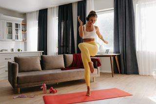 A woman doing a dance workout in her home.