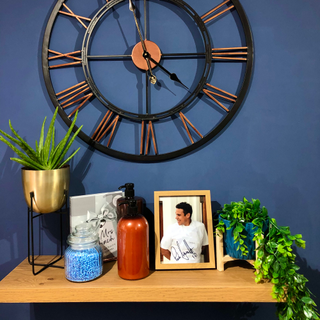 blue wall with wooden shelf and wall clock