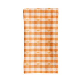 An orange and white gingham napkin with pumpkin motifs on it