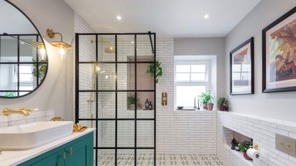 Bathroom with black steel panelled shower wall, green vanity and grey and white patterned floor tiles, with small white brick wall tiles around the shower