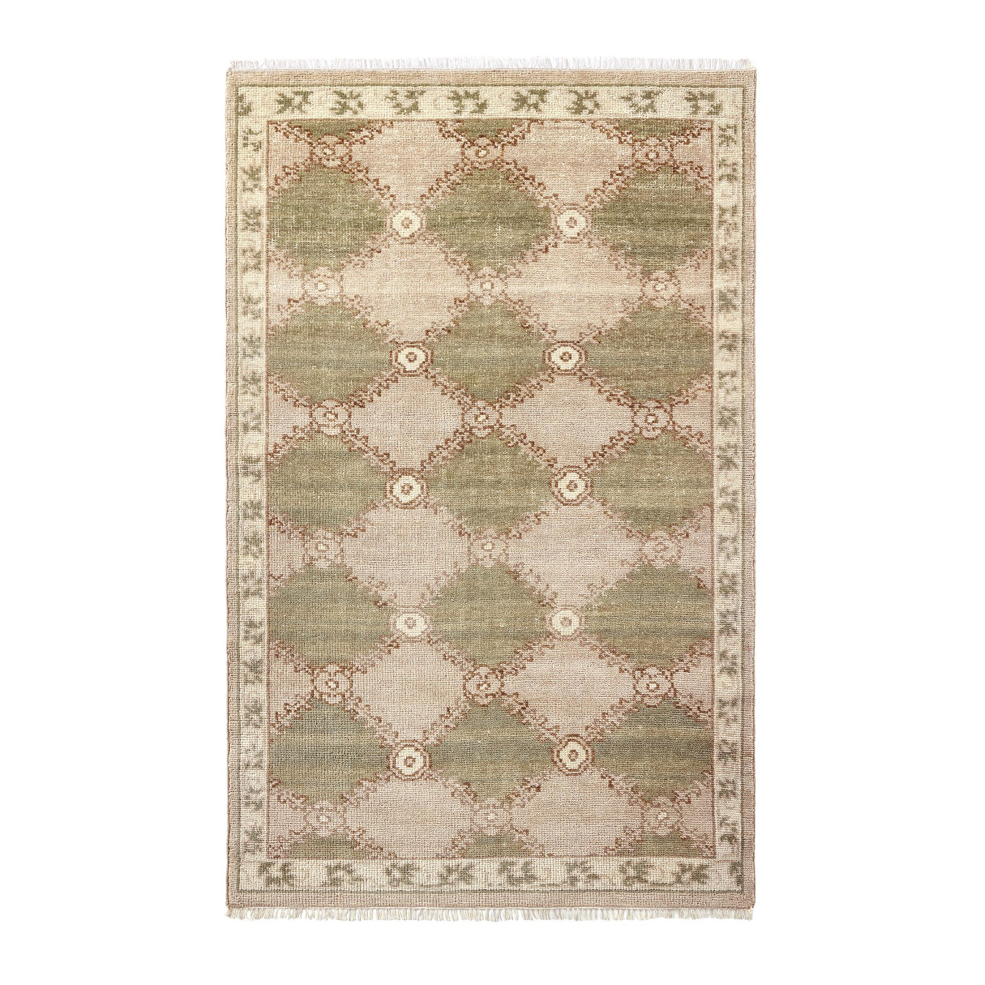 a vintage inspired rug in green and beige