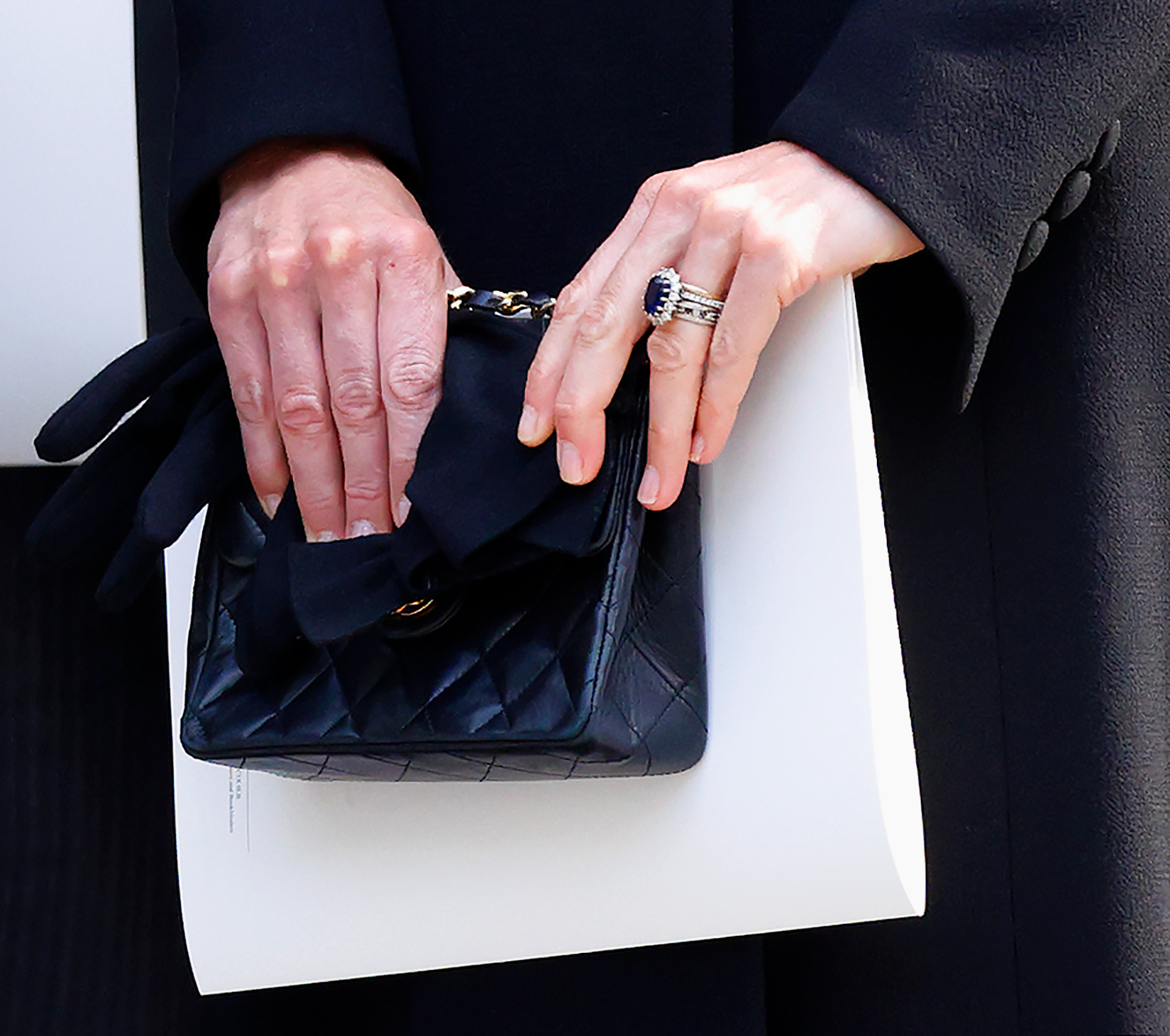 Closeup of Kate Middleton&#039;s hands holding a black Chanel bag