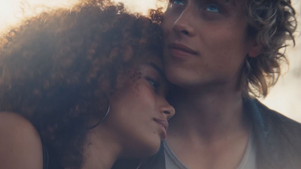 A woman nuzzling the neck of a man in Sunrise on the Reaping