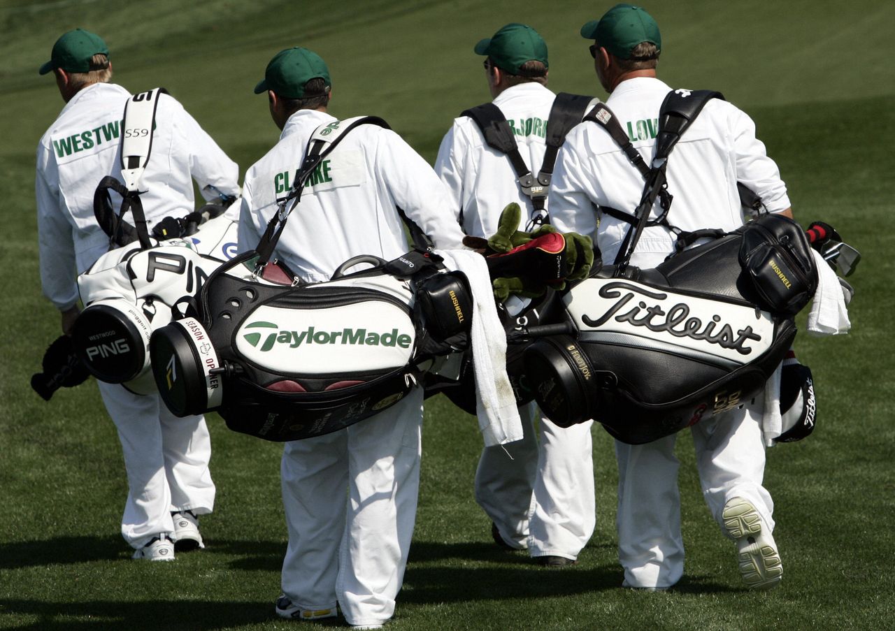 The Masters Caddies: Four caddies walk down the fairway at Augusta National