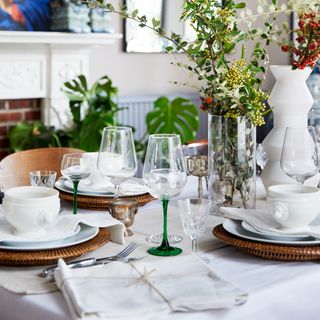 Assortment of dining plates and utensils, flowers on table