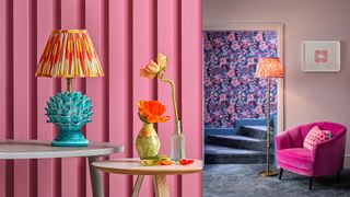 bright pink wall with colourful maximalist lighting and a patterned wallpaper framed with pale pink paintwork