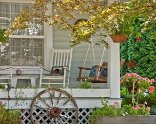 detailed area of a home showing a summertime class porch scene with a swing, rocking chair