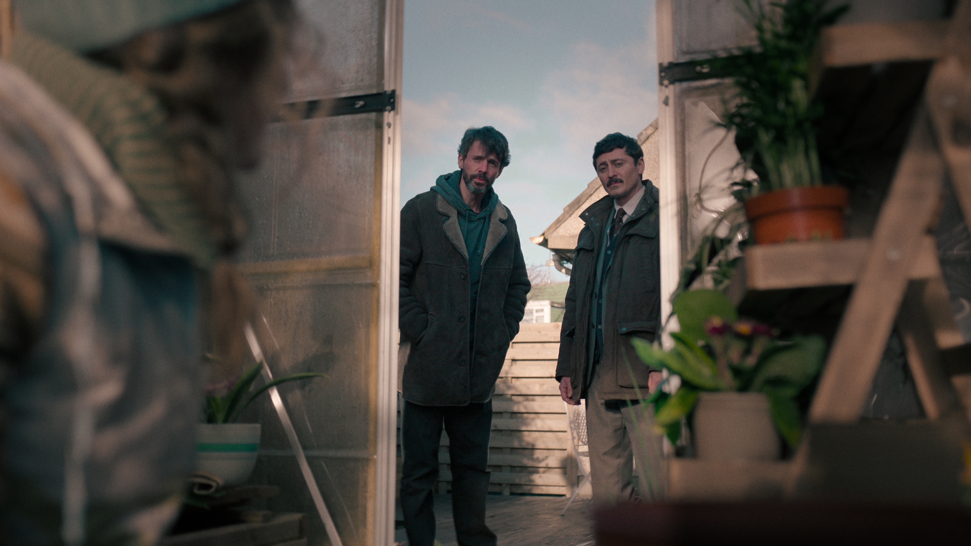 Carl and Akram stare at Claire in a greenhouse in Department Q