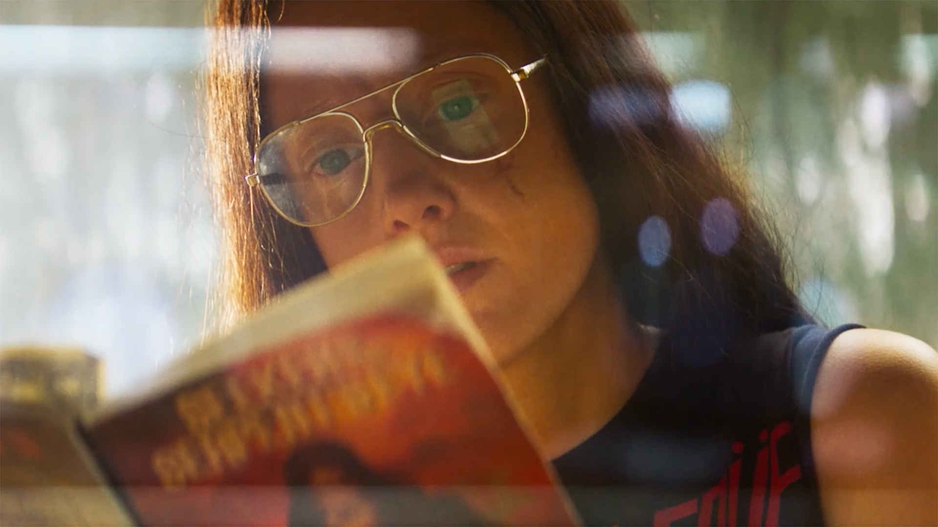 Andrea Riseborough as Mandy Bloom, reading a book, in Mandy.