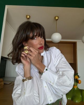 French woman Julie Sergent Ferreri wearing white shirt with bright red lipstick and gold jewellery