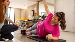 Young woman doing one of the best ab exercises: side plank