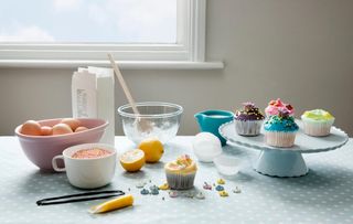 a Still life photo of cakes and baking supplies such as flour and eggs