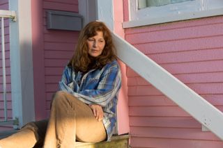 Catherine Keener sits on the steps of her house