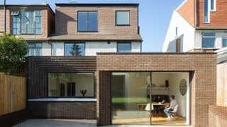 rear brick extension with large sliding patio doors and a detailed corbelled brickwork finish to one side of the extension