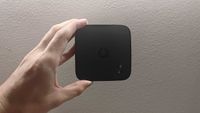 A picture of a hand holding a Vodafone TV streaming box