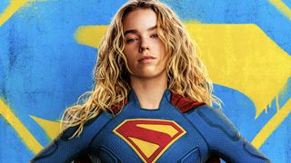 Supergirl in costume in front of blue and yellow logo in Supergirl poster