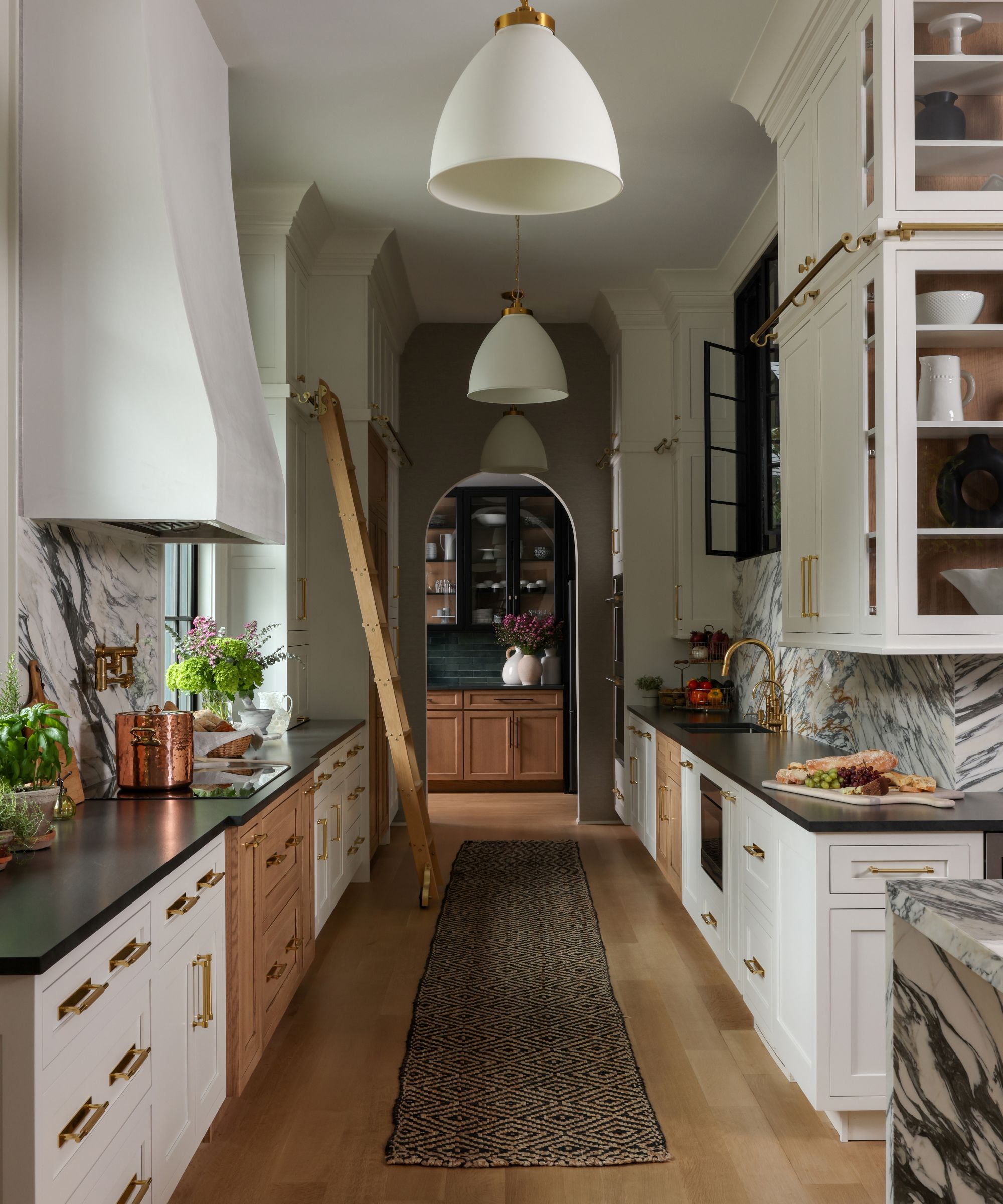 white kitchen with library ladder and rug