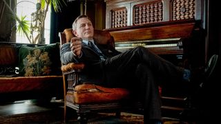 Daniel Craig's Benoit Blanc sits in a chair in 2019's Knives Out movie