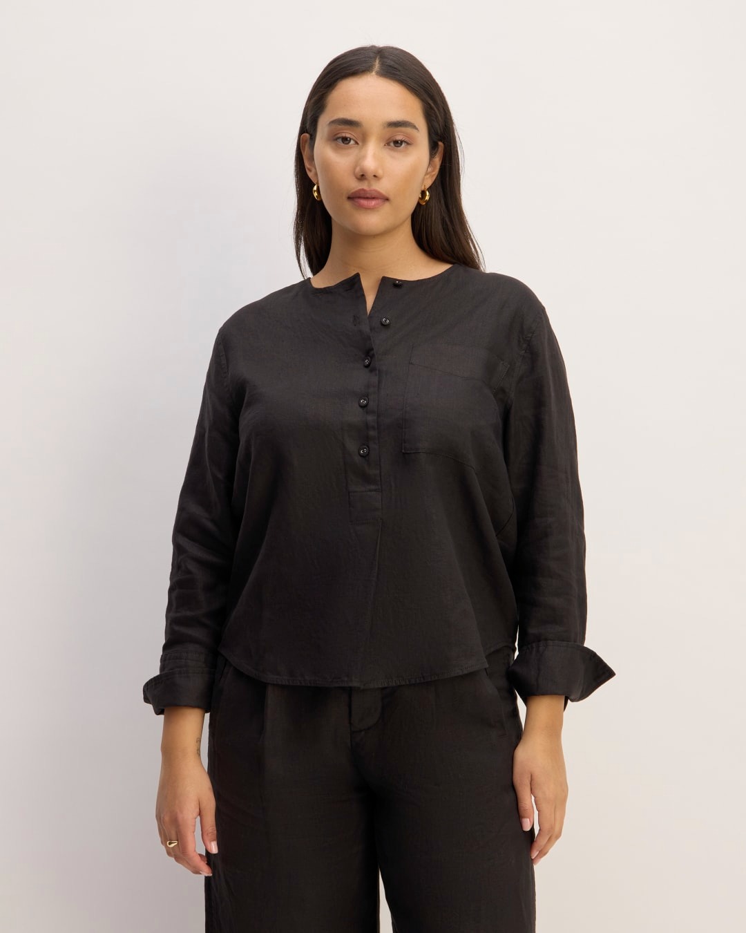 a model wears a black long-sleeve linen shirt with buttons