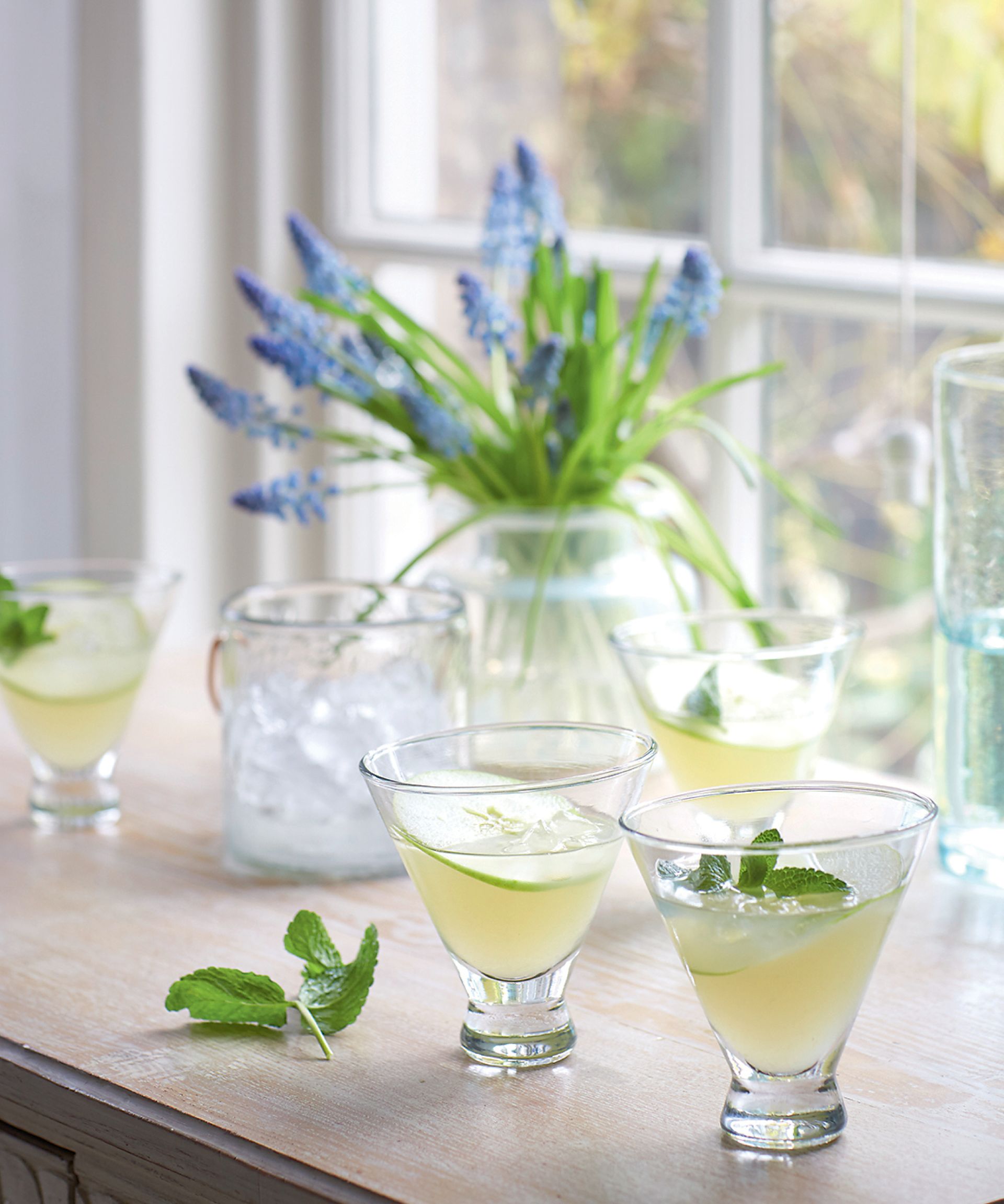 Spring cocktail on a windowsill with flowers in the background