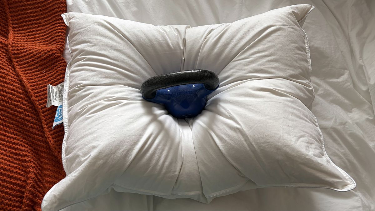 A 10lb weight balanced on the center of the Downright Mackenza Pillow showing the cushioning and support.
