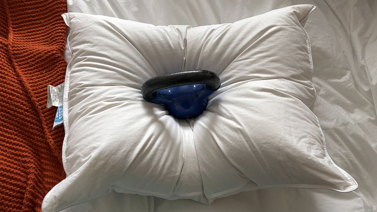 A 10lb weight balanced on the center of the Downright Mackenza Pillow showing the cushioning and support.