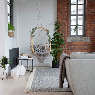 living room with red brick and white wall swing and wooden flooring