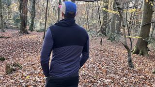 Man wearing Icebreaker Merino Blend 200 Realfleece Descender Hoodie, shown from the back, in the forest