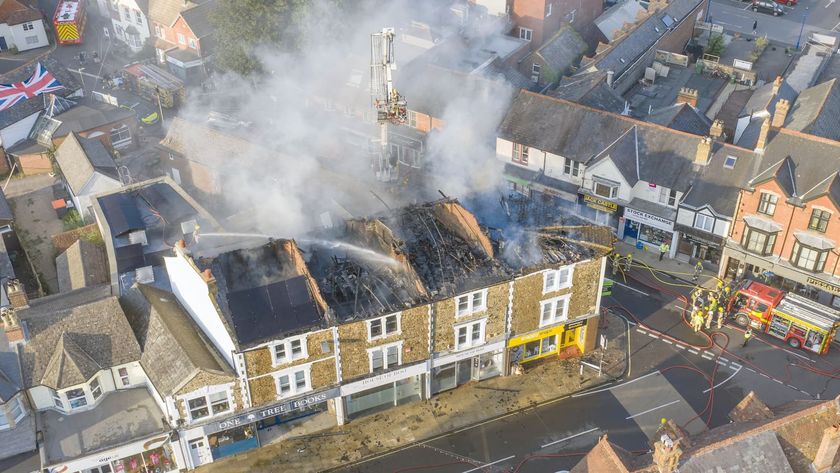 An aerial view of the entire top floor of a row of shops and flats on fire on July 3,2025 in Petersfield, England
