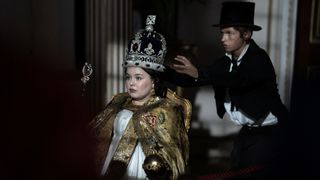 Billy Jenkins as Dodger holds out his hands to steal the crown being worn by Nicola Coughlan as Queen Victoria in Dodger.