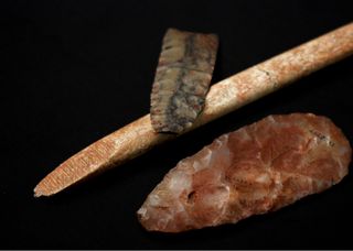 A nearly complete projectile point of dendritic chert, a mid-interval biface of translucent quartz, displaying relatively heavy red ochre residue and an "end-beveled" osseous rod, also exhibiting red ochre residue. These artifacts are technologically consistent with artifacts of the Clovis complex.