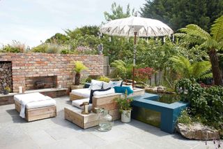 low maintenance garden ideas: urban space with fireplace and parasol