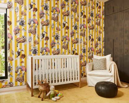 Nursery with bright yellow, striped wallpaper, white crib and lounge chair with brown leather footstool and yellow rug