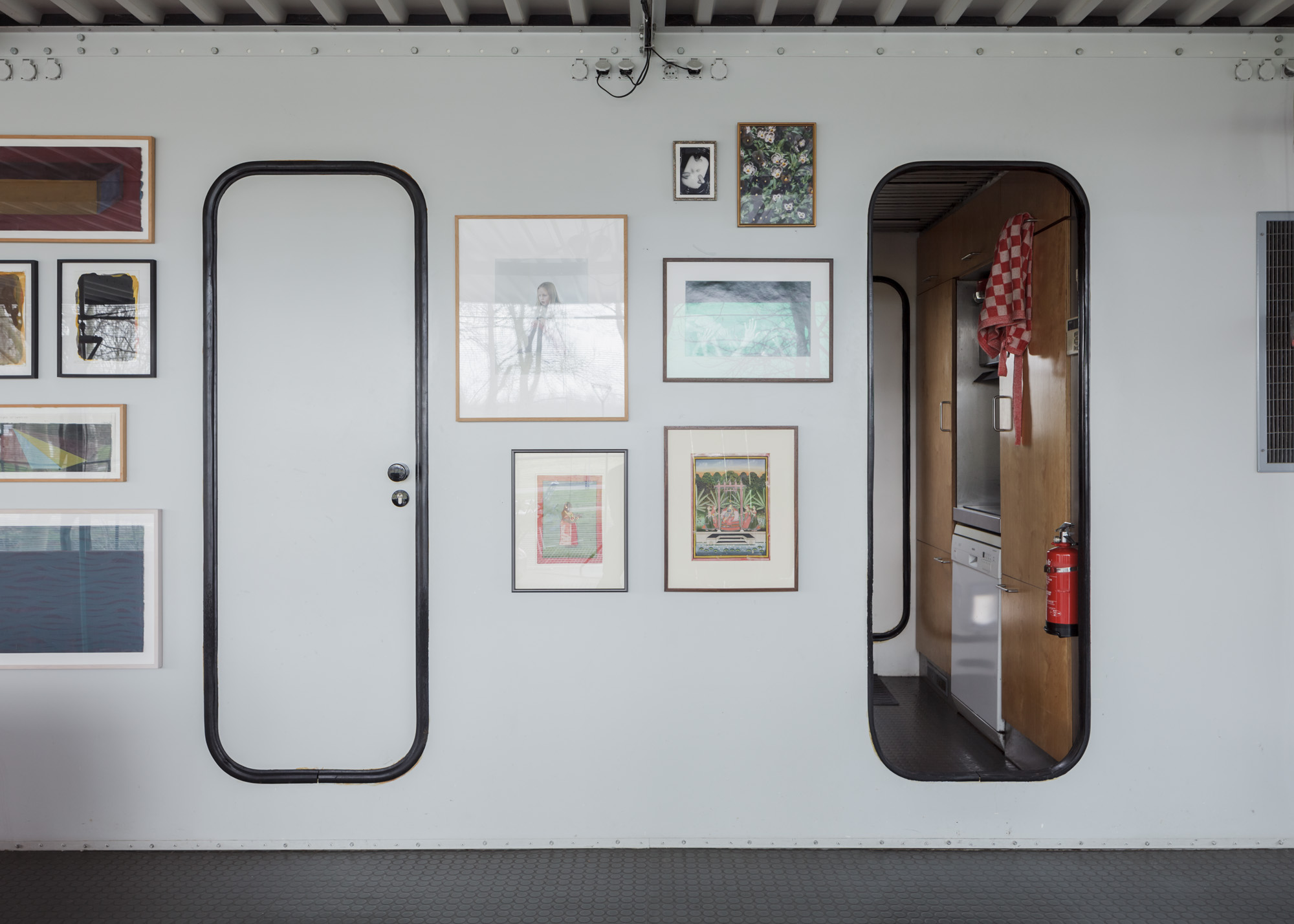 a grey wall with two doorways and picture frames