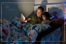 Dad reading to his son in bed