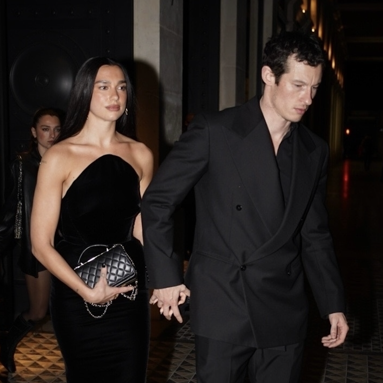 Dua Lipa and Callum Turner exude sophistication as they leave a restaurant hand-in-hand, heading to their hotel. Dua stuns in a strapless black velvet gown, while Callum complements her in a tailored double-breasted black suit, making a coordinated and stylish statement. on Jan. 28