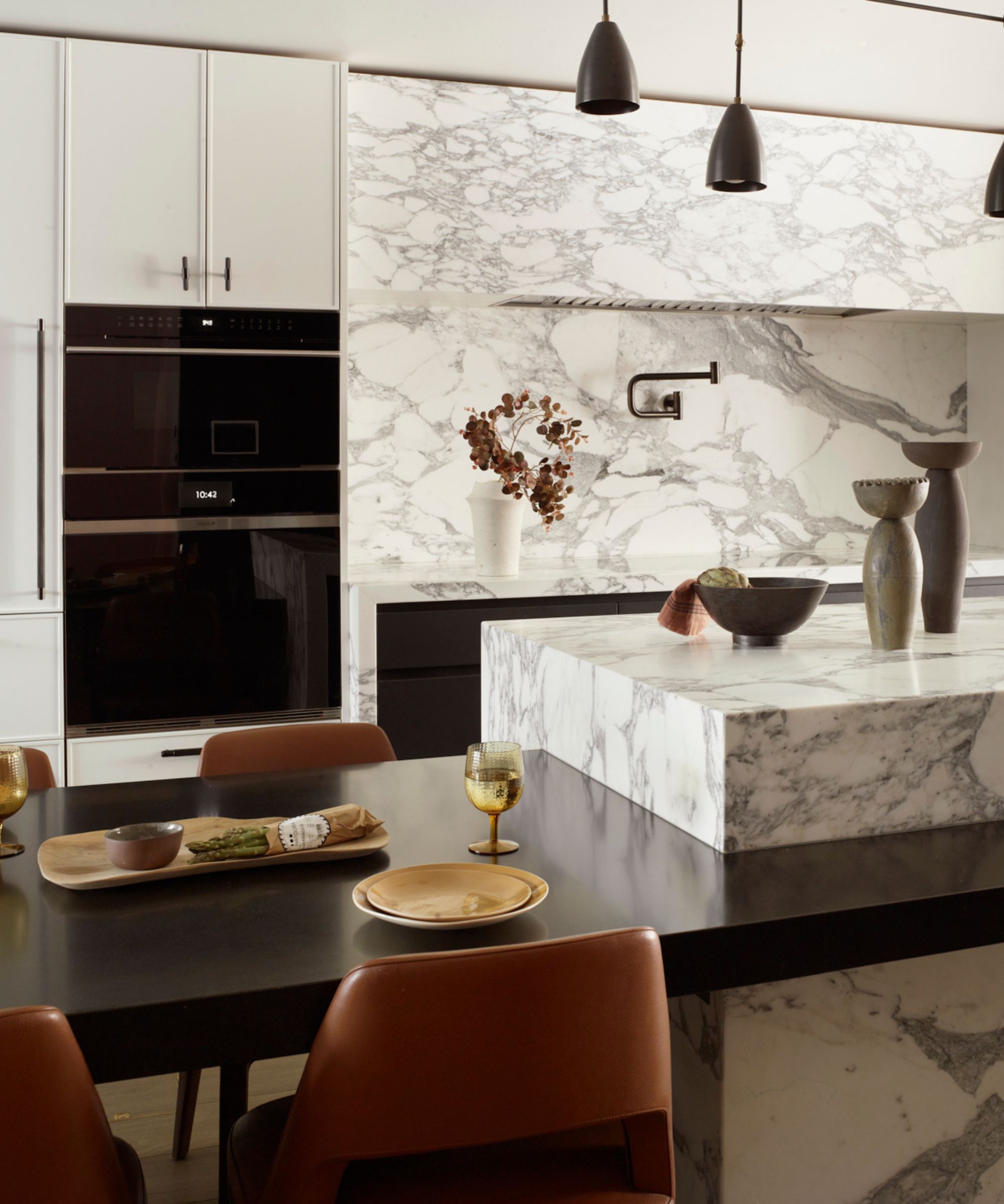 A marble kitchen with an island and a built-in dining table