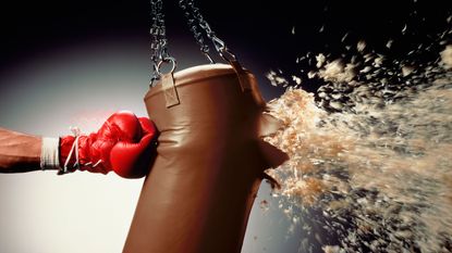 picture of man punching punch bag and stuffing exploding from bag