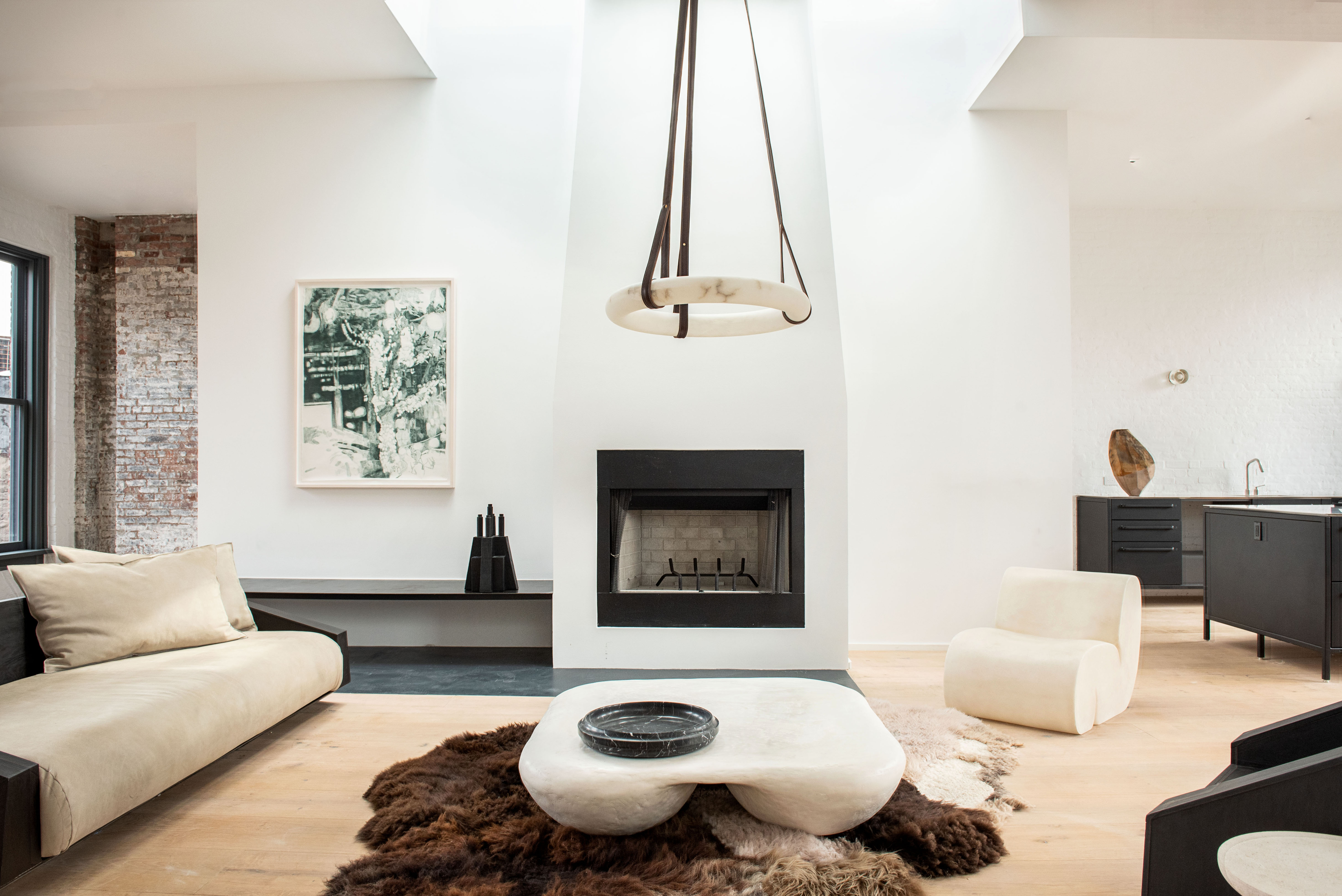 Galerie Philia exhibition space with white sofas, fireplace and white chunky coffee table