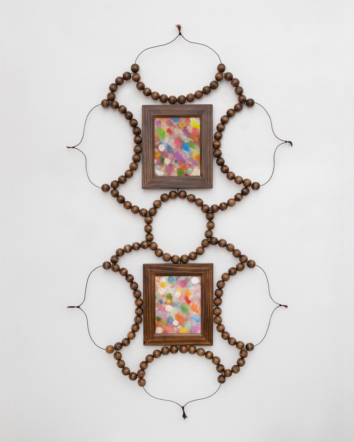 Two wall art pieces made of wood, pearl, beads, and canvas emanate an organic, rustic essence and lots of color.