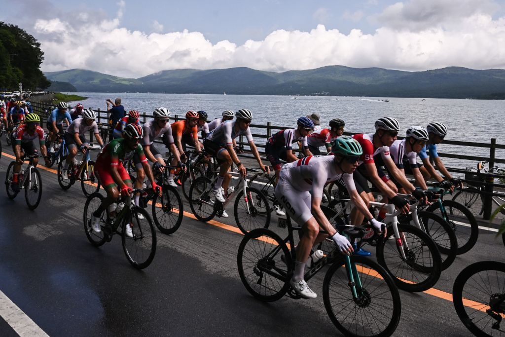 Norways Andreas Leknessund front R rides in the peloton past Yamanaka Lake during the mens cycling road race during the Tokyo 2020 Olympic Games in Yamanashi Prefecture Japan on July 24 2021 Photo by Jeff PACHOUD AFP Photo by JEFF PACHOUDAFP via Getty Images
