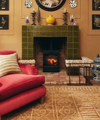 green tiled fire surround with a log burner and fall inspired decor candles and vases