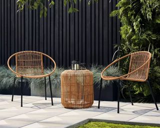 A contemporary rattan bistro set on a paved patio