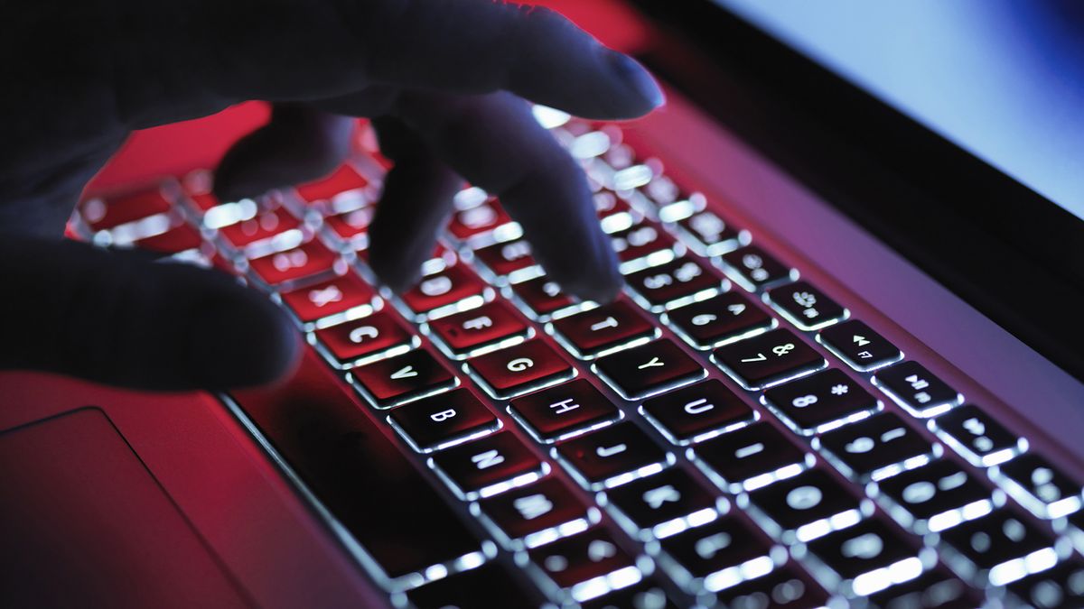 A close up shot of two hands typing on a laptop. 