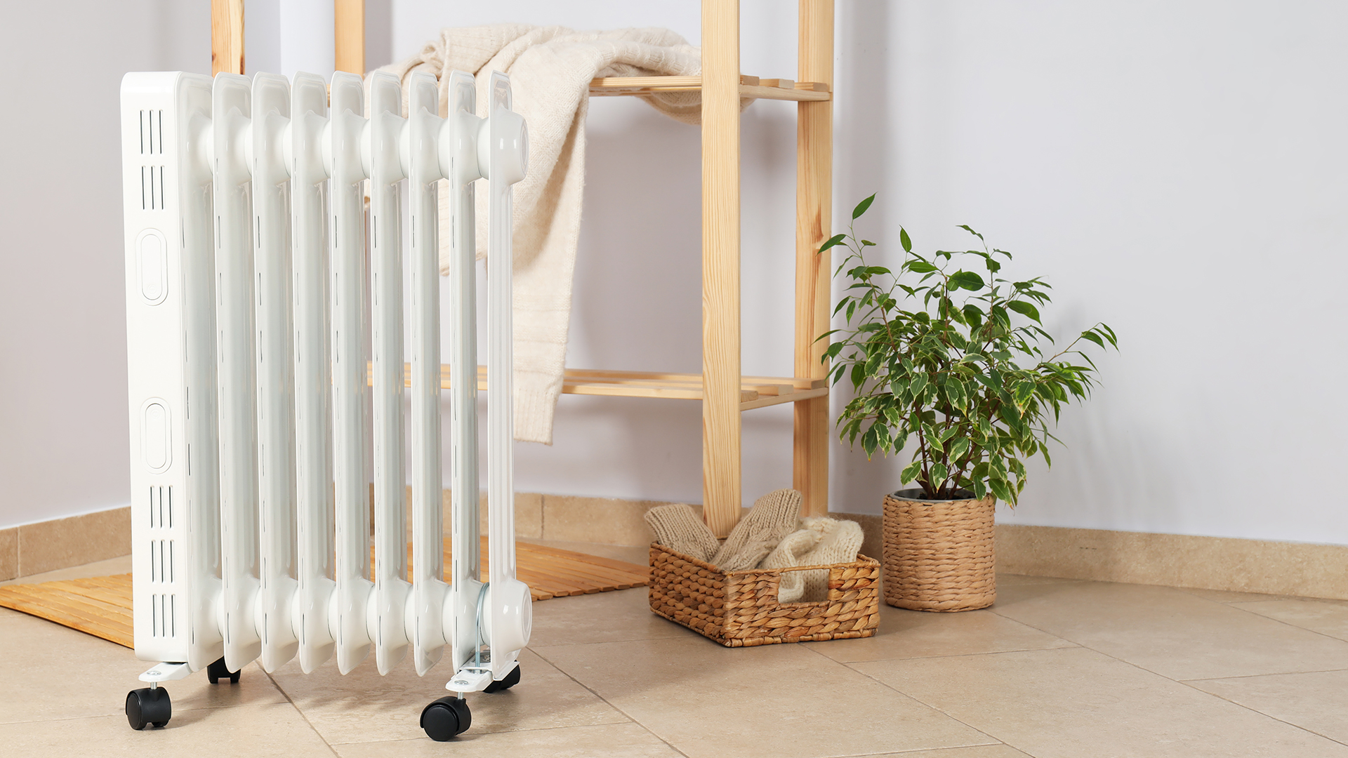 Portable electric heater on castor wheels in a bathroom with a set of wooden shelves