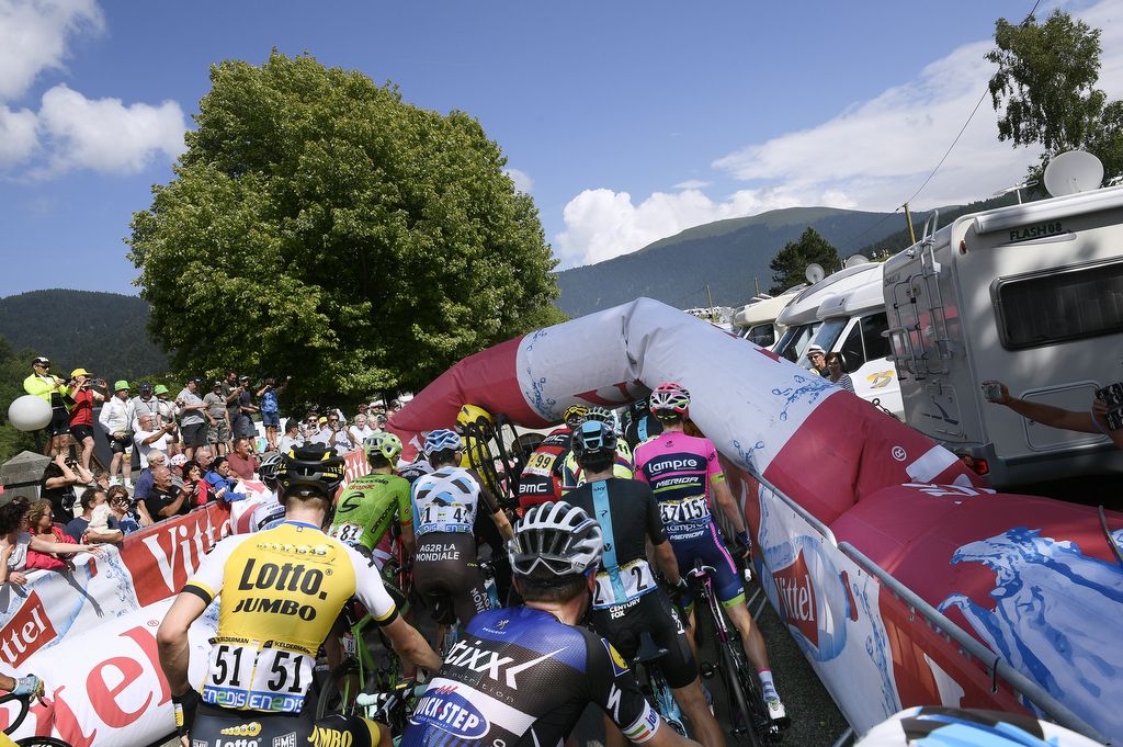 The riders are held up after the inflatable flamme rouge banner collapsed