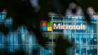 Microsoft logo on a building, obscured by trees