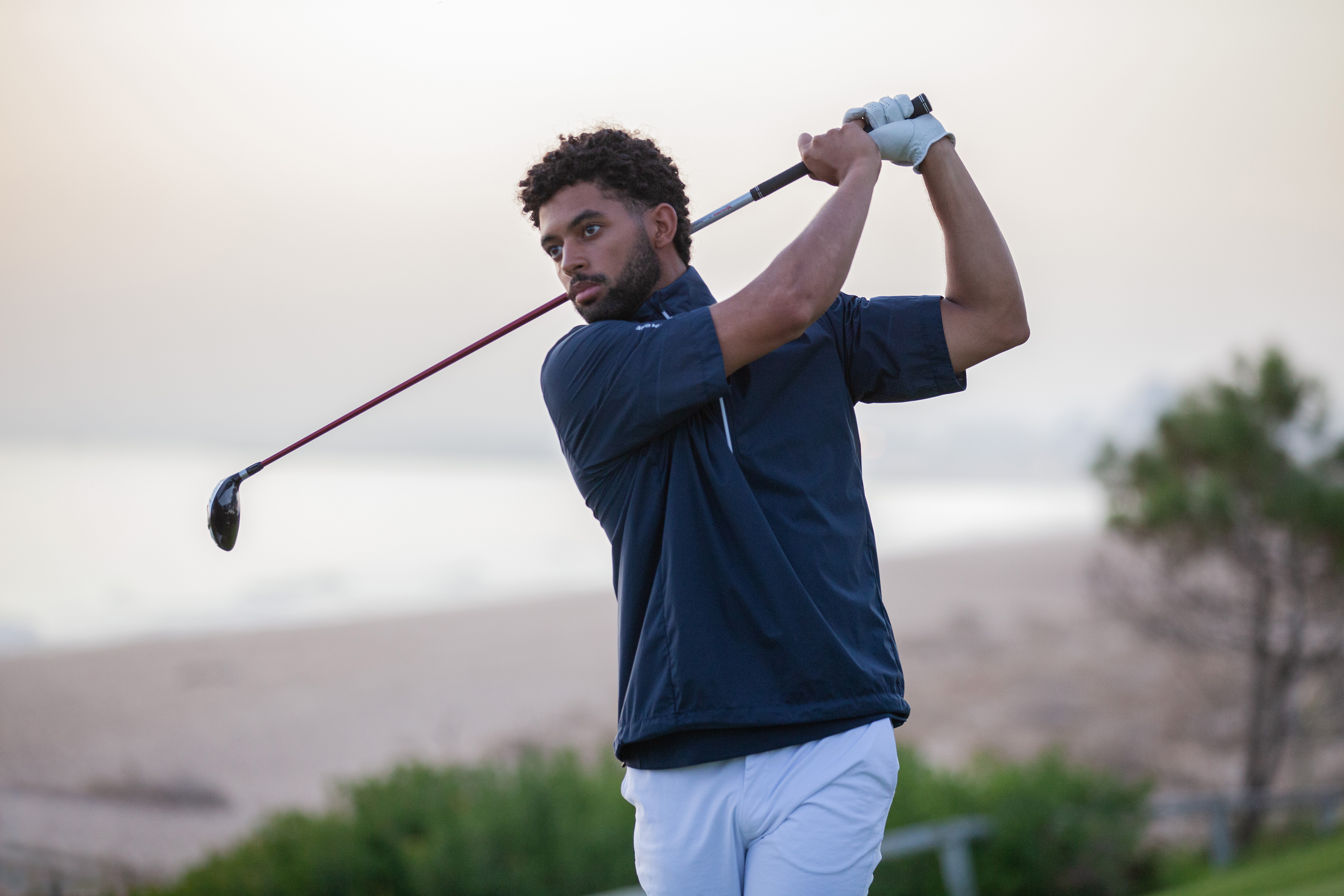 A golfer holds their finish on a fairway wood shot