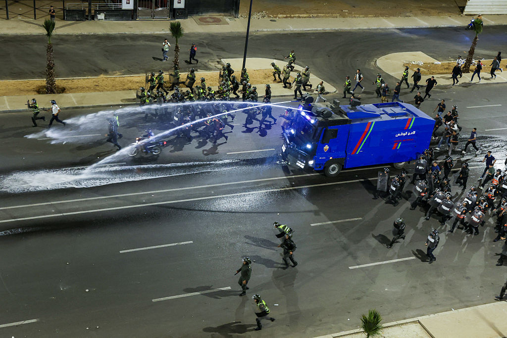 Security forces advance with a water-cannon vehicle to disperse protesters during a youth-led demonstration demanding reforms in the healthcare and education sectors in Sale